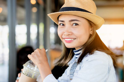 Portrait of smiling young woman drinking coffee