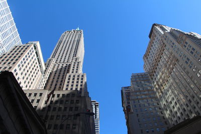 Low angle view of buildings against clear blue sky