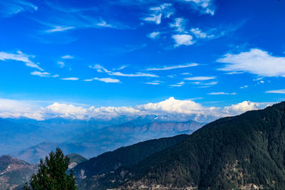 Scenic view of mountains against blue sky