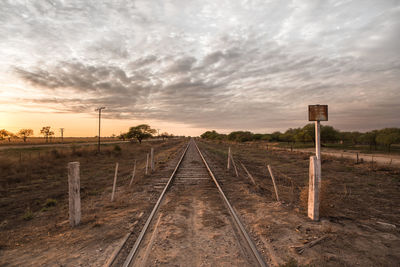 Railroad tracks against sky during sunset