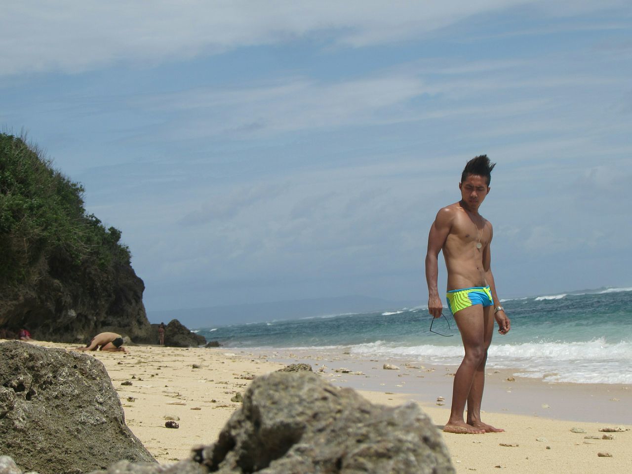 beach, sea, lifestyles, water, leisure activity, full length, shore, sand, sky, horizon over water, casual clothing, young adult, vacations, person, young men, shirtless, rock - object, wave