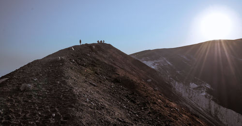 People on mountain against sky