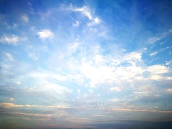 Low angle view of sunlight streaming through clouds