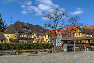 Houses and buildings in town against sky