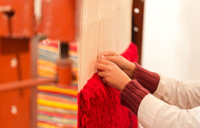 Close-up of woman making rug with wool at workshop