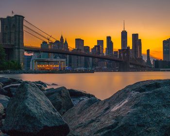 Bridge over river in city during sunset