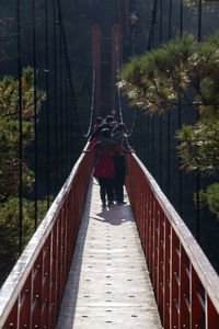 Rear view of man walking on footbridge