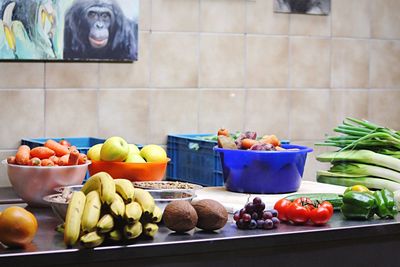 Healthy fruits and vegetables on counter against wall