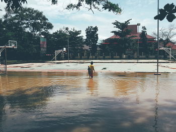 Reflection of man in puddle on swimming pool