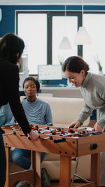 Happy colleagues playing foosball at office