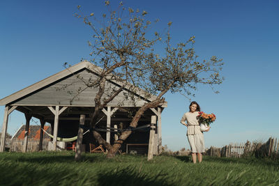 Woman standing on field against sky