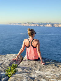 Rear view of woman looking at sea against sky