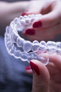 Cropped hand of woman holding dental aligner