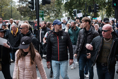 Group of people walking on street in city