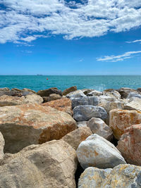 Rocks on sea shore against sky