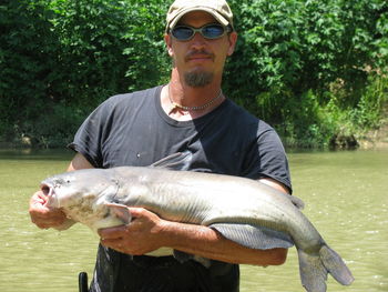 Man holding fish at shore