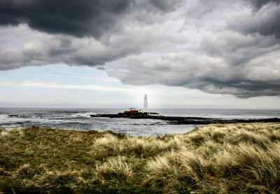 Boat sailing in sea against cloudy sky