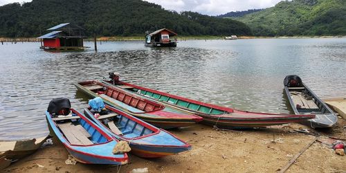 Boat moored on lake against mountain