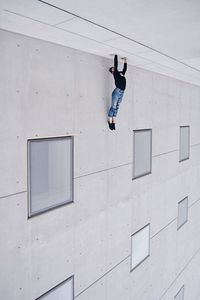 Full length of man climbing on wall