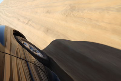 High angle view of wheel in sand dunes in desert