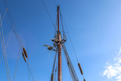 Sailing ship mast against the blue sky on some sailing boats with rigging details