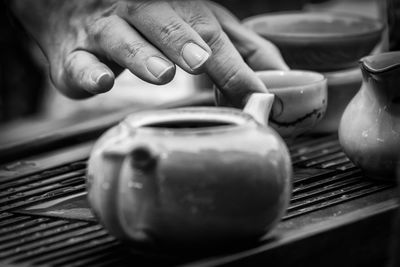 Cropped hand having tea on table