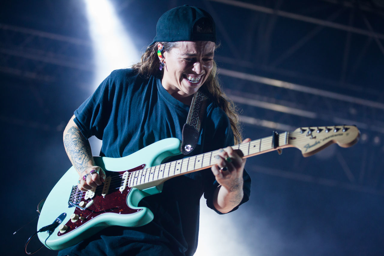 YOUNG MAN PLAYING GUITAR AT CAMERA