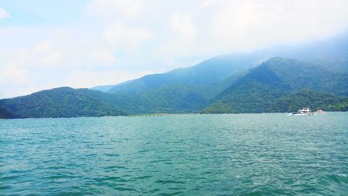 Scenic view of sea and mountains against sky