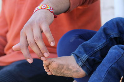 Midsection of man touching baby feet