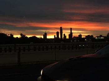 Silhouette buildings against sky at sunset