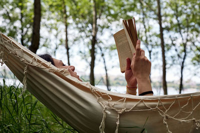 Cropped hand of woman standing in forest