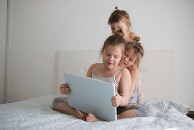 Girls are funny crazy kids argue over the laptop, the concept of childhood and gadgets, life