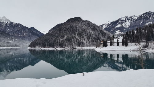 Scenic view of lake and snowcapped mountains against clear sky