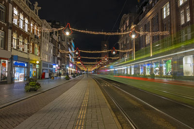 Tram driving on damrak in christmas time in amsterdam netherlands