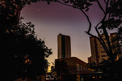 Silhouette buildings against sky at dusk