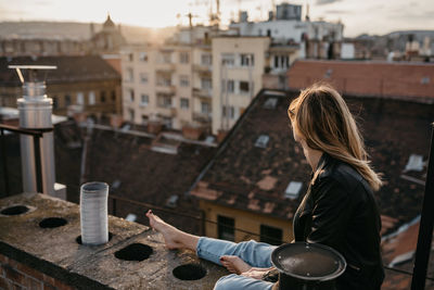 Woman standing against buildings in city