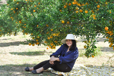 Portrait of smiling young woman against trees