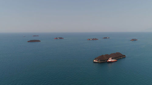 Aerial view barges full coal anchored at sea near coal fired power station waiting be transported. 