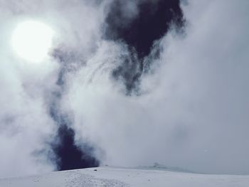 Smoke emitting from volcanic mountain against sky