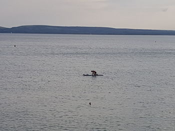 Man in boat on sea against sky