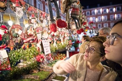 Woman with granddaughter buying decorations during christmas at night