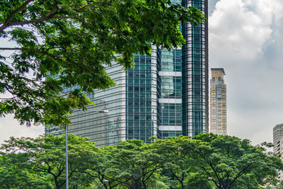 Low angle view of trees and buildings against sky