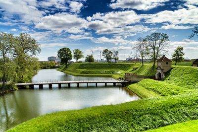 Scenic view of river against cloudy sky