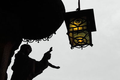 Low angle view of illuminated lantern hanging against sky