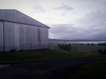 Built structure on field against cloudy sky