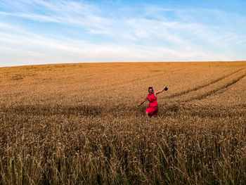 Woman standing on field against sky