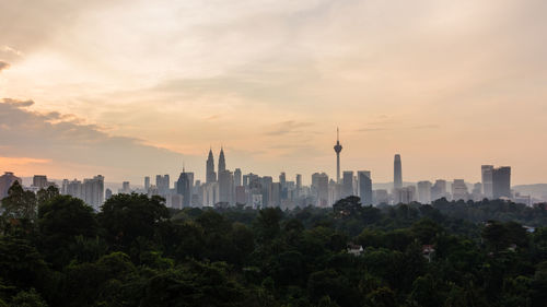 View of buildings in city against sky during sunset