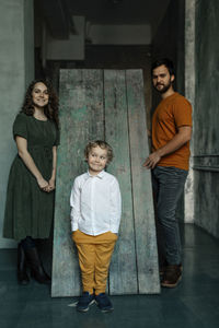 Portrait of friends standing against wall