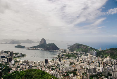 High angle view of cityscape by sugarloaf mountain against cloudy sky