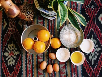 Directly above shot oranges with eggs and flour on table